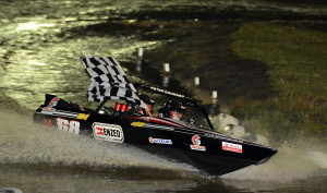 Defending NZ champion Peter Caughey with the chequered flag at the final round of the jetsprint NZ champs at Wanaka (photo Ian Thornton)